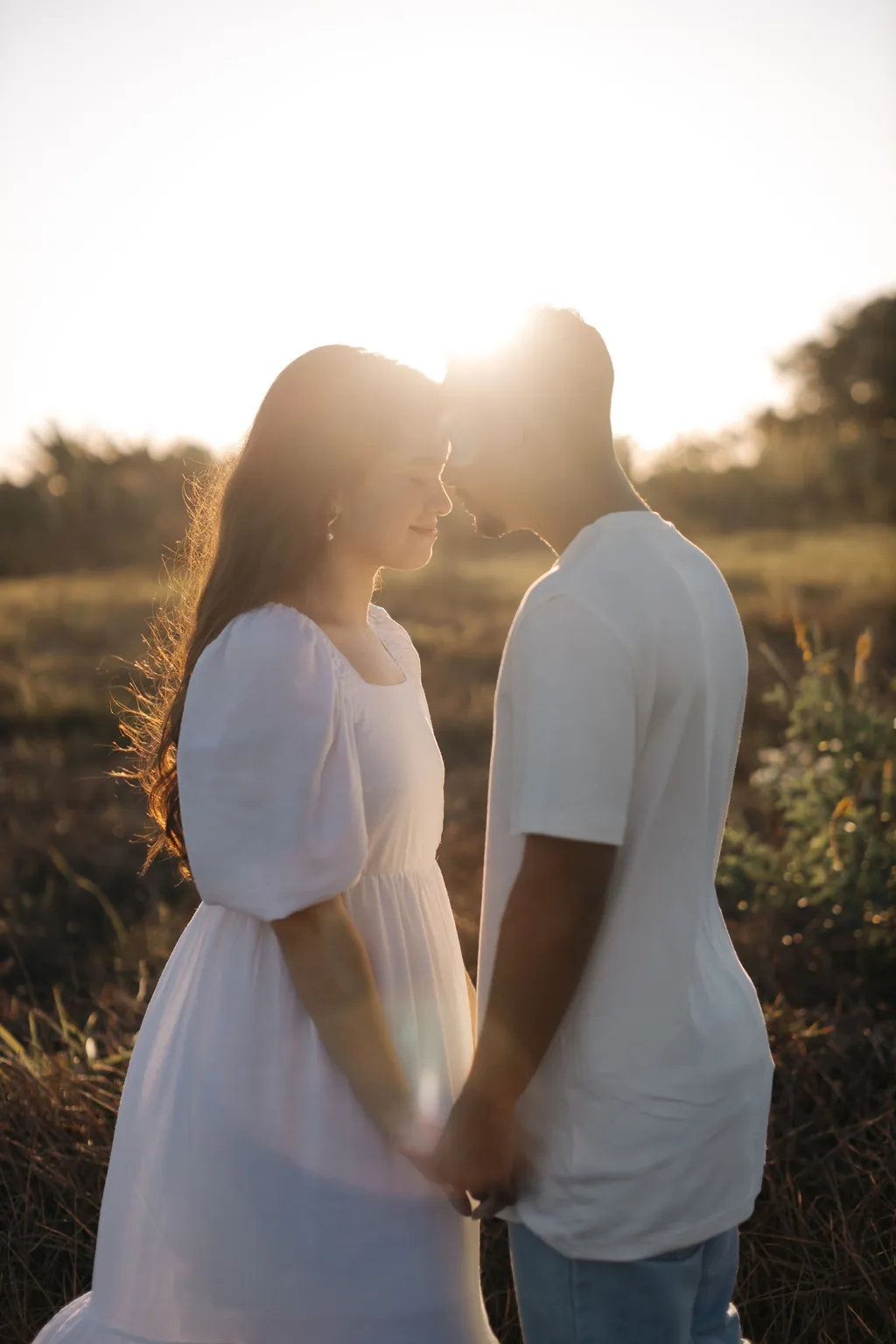 Casal de mãos dadas no campo ao entardecer