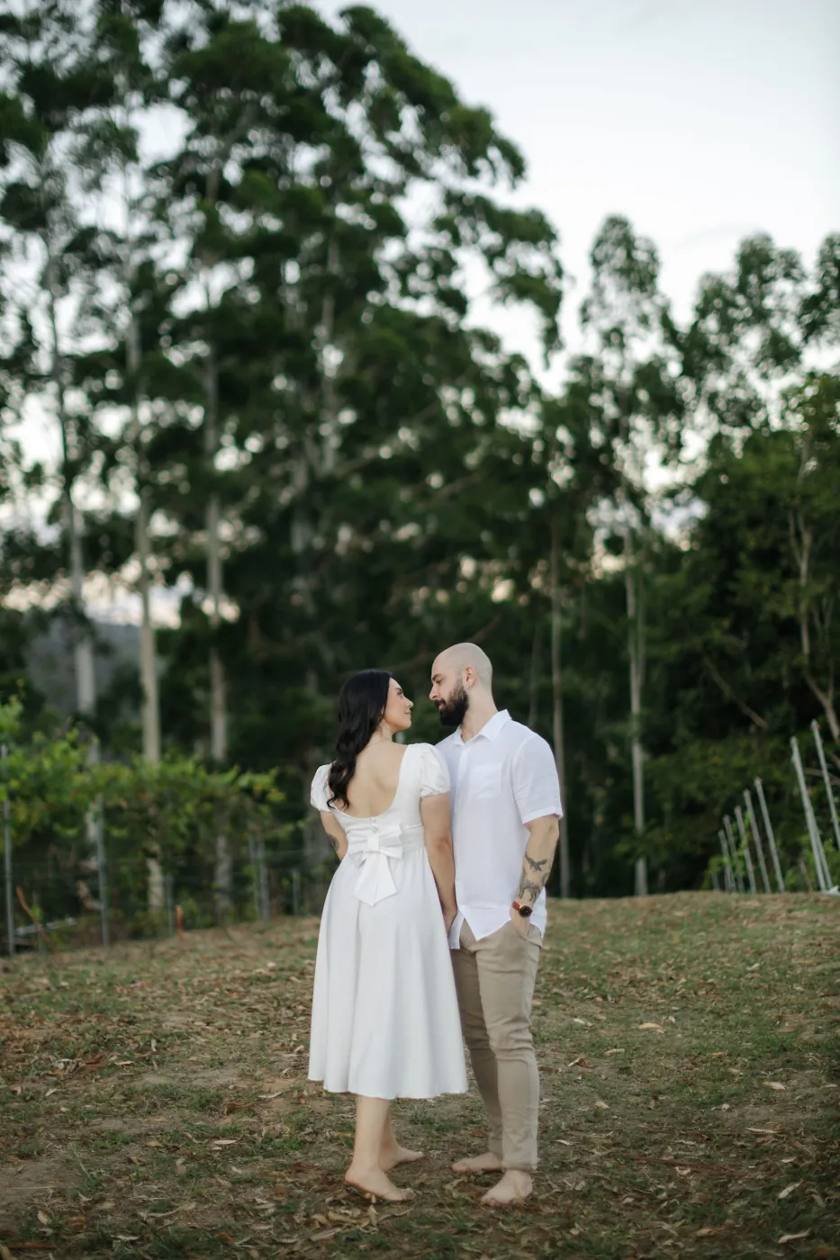 Casal testa com testa no gramado ao fim da tarde