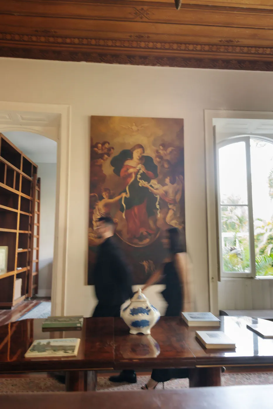 Casal atravessando a sala com o quadro antigo, em movimento