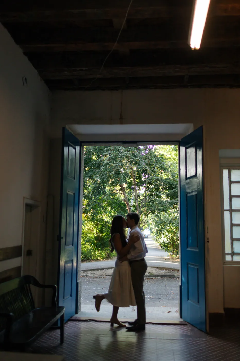 Silhueta do casal se beijando na porta aberta, contra a luz da rua